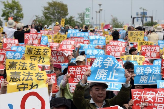 Citizens holding placards attend a protest rally in Tokyo, Japan, May 3, 2016. Some 50,000 people rallied in Tokyo on Tuesday on the occasion of the 69th Constitution Memorial Day of Japan to protest against Japanese Prime Minister Shinzo Abe's unwanted attempts to amend the nation's pacifist Constitution. (Xinhua/Ma Ping)