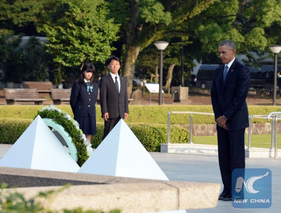 U.S. President Barack Obama (R) stands in silent tribute in front of the cenotaph during his visit to the Hiroshima Peace Memorial Park in Hiroshima, Japan on May 27, 2016. (Xinhua Photo by Ma Ping)