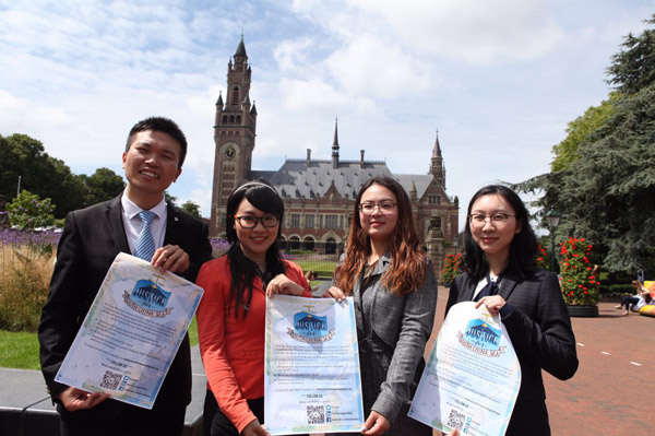 Overseas scholars of international law hold copies of the United Nations Convention on the Law of the Sea (UNCLOS) in hands in front of the Peace Palace in Hague, Netherlands on July 8, 2016. They try to seek justice of the international law by publicizing an open letter about scholars' professional stance on the South China Sea case. (Photo by Fu Jing/China Daily)