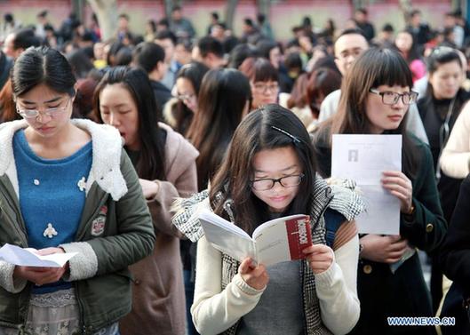 Candidates review before the civil servant recruitment exam of Jiangsu Province at Nanjing Forestry University in Nanjing, capital of east China's Jiangsu province, March 22, 2015. More than 190,000 candidates here will compete for 5,872 positions this year. (Photo by Liu Jianhua/Xinhua)