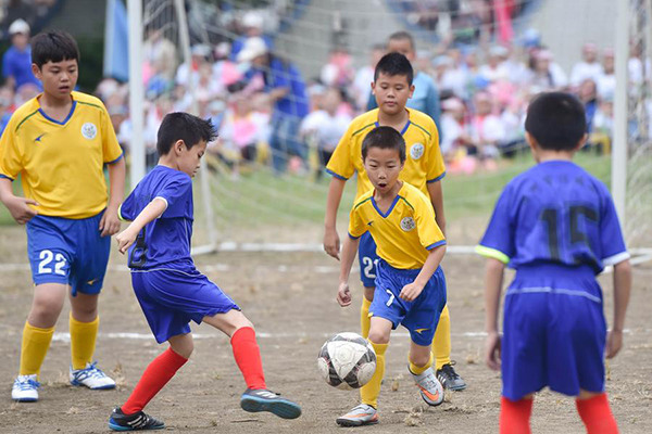 Pupils play football in the 1st School Football Culture Festival of Xiangban Primary School in Fuzhou, the capital of Southeast China's Fujian province, on May 20, 2016. (Photo/Xinhua)