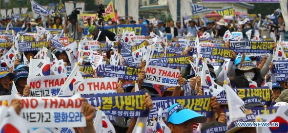 People from Seongju county hold the national flags of South Korea and banners to protest against the deployment of the Terminal High Altitude Area Defense (THAAD), during a rally in Seoul, capital of South Korea, on July 21, 2016. (Xinhua/Yao Qilin)