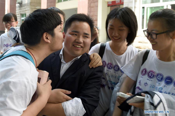 A student gives a goodbye kiss to his teacher at Maotanchang High School in Maotanchang town of Lu'an city, East China's Anhui province, June 4, 2016.(Photo/Xinhua)