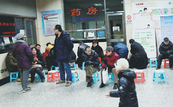 Patients wait in line for the registration windows to open at the Beijing Stomatological Hospital on Wednesday. The windows open at 7 am to sell tickets for treatment, and it is a common practice for people to use stools or other objects to reserve a place in the line.(Photos by Zou Hong / China Daily)