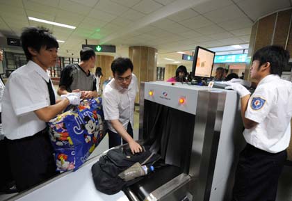 A passenger has his luggage inspected at the entrance of a subway station in Beijing June 29, 2008. (Photo/Xinhua)