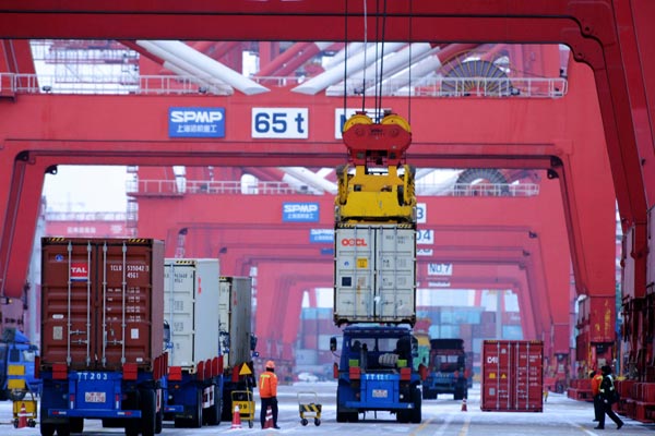A ship loads containers at a terminal in Qingdao, Shandong province. China is poised to open up its market further to foreign investment. (Photo/China Daily)