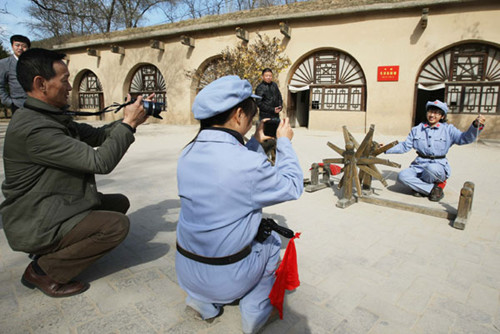 Tourists dressed as Red Army soldiers pose for pictures at the Zaoyuan historical site in Yan'an, Shaanxi province (File Photo: Xinhua/Li Fangyu)