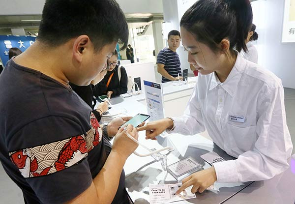 A visitor inquires about a Samsung smartphone at an international telecom expo in Beijing. (Photo/A Jing, China Daily)