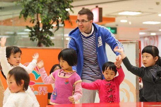 Belgian John Lee plays with children from an early education center in Tianjin on April 5. He can speak Chinese fluently, and is now one of the most popular teachers in the center. (Photo provided to China Daily)