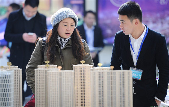 A woman talks with a salesman at a property market fair in Hangzhou, Zhejiang province.(Photo/China Daily)