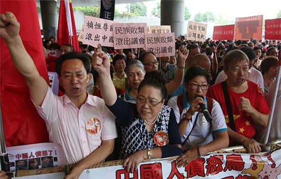 Residents hold placards and shout slogans outside the Legislative Council in Hong Kong on October 19 to protest the retaking of the Legislative Council oath by lawmakers-elect Yau Wai-ching and Sixtus Leung Chung-hang. (ROY LIU/CHINA DAILY)