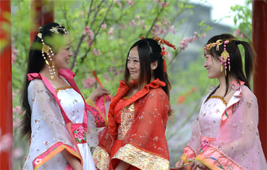Girls in traditional Chinese costumes enjoy a spring tour in Fantawild park in Wuhu, Anhui province. (Lai Xinlin / For China Daily)