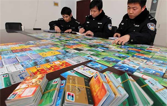 Police officers make a list of bank cards seized in a telecommunication fraud case in Xuchang, Henan province, in January. (NIU YUAN/CHINA DAILY)