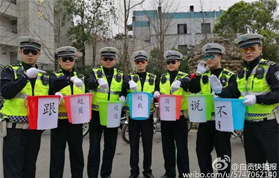 Police officers hold the buckets stuck with road safety slogans.(Photo from Sina Weibo)