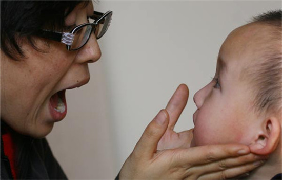 Wang Ming instructs an autistic 3-year-old in Lanzhou, Gansu province. Wang must repeat the same word as many as 1,000 times before the child can pronounce it. (Cao Zhizheng / for China Daily)