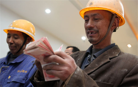 Migrant workers receive their pay at a construction site in Dazu district, Chongqing, on Dec 26, 2013. (Photo/China Daily)