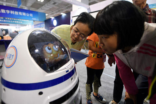 Visitors communicate with a robot named Xiaopang at the 2016 China Lanzhou Science and Hi-Tech Achievement Expo on Sept 24. (Photo/Xinhua.net)