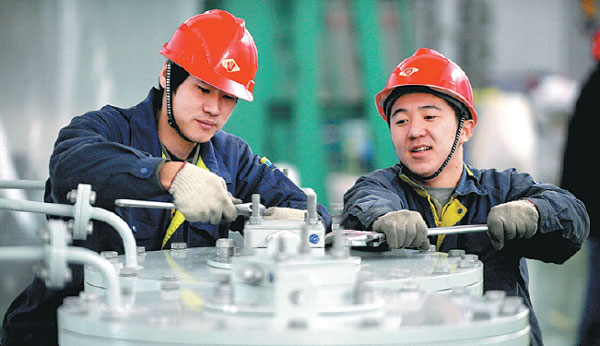 Workers from TBEA Shenyang Transformer Group Co assemble equipment in a plant in Shenyang, Liaoning province. (Photo by Zhang Wenkui/For China Daily)