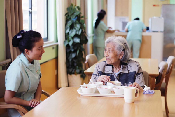 An undated photo shows an elderly woman dining at a nursing home in Hangzhou. (Sun Yidou/For China Daily)
