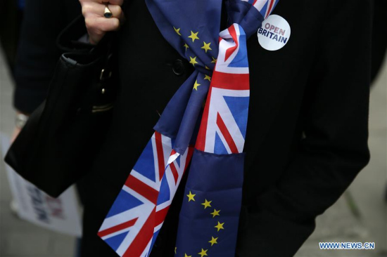 A demonstrator wearing a scarf made of UK and EU flags is seen in London, Britain on March 29, 2017. Britain will trigger its exit from the European Union on Wednesday, nine months after the country voted to leave the European Union. (Xinhua/Tim Ireland)