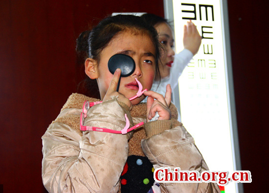 A girl, Ruru, has an eyesight test in Huaiyang county, Zhoukou in Henan province. She and her two siblings suffer from severe nearsightedness. (Photo/China.org.cn)