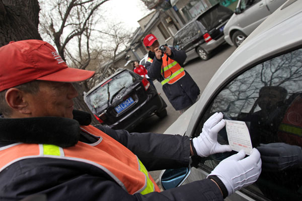 A traffic police assistant tickets an improperly parked vehicle in Beijing. WANG WEI / FOR CHINA DAILY