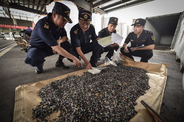 Employees of Shenzhen Customs display seized solid industrial waste which was smuggled into China. (Photo/Xinhua)