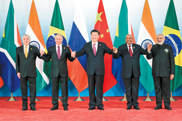 President Xi Jinping and other leaders of BRICS countries pose for a group photo before the Ninth BRICS Summit in Xiamen, in Southeast China's Fujian province, on Monday. The five leaders then took up many issues at the start of the event. (WU ZHIYI / CHINA DAILY)