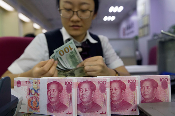 A clerk counts money at a bank in Taiyuan, North China's Shanxi province. (Photo/China News Service)
