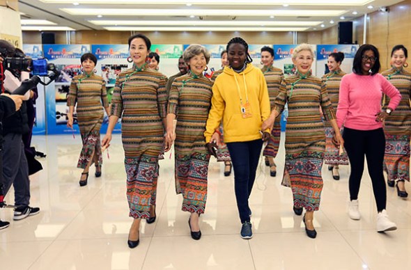 Overseas journalists in China to report about the 19th National Congress of the Communist Party of China join a modeling performance team on Saturday at the Chaoyang Elder Care Service Guidance Center, in Beijing's Chaoyang district, during a visit. The amateur models are all residents from nearby neighborhoods and are more than 60 years old. (WANG ZHUANGFEI/CHINA DAILY)
