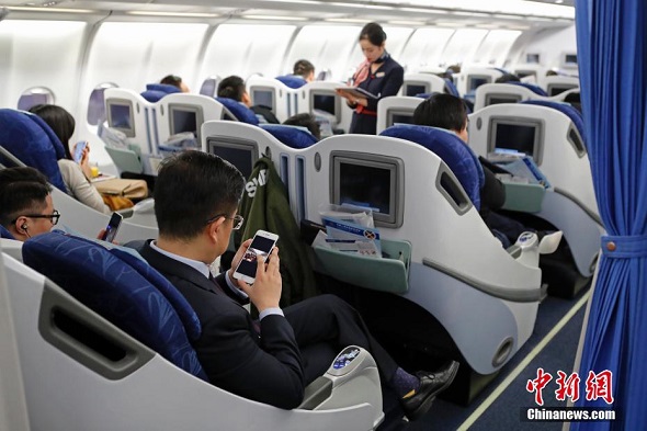 Picture taken on Jan. 18 shows passengers using mobile devices in China Eastern Airlines' flight. (Photo/Chinanews.com)