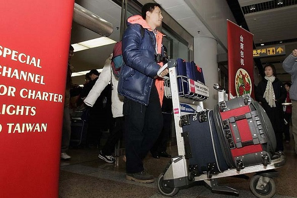 Passengers make their way out of the arrival lounge after arriving on Taiwan's China Airlines (CAL) plane at Beijing Capital International airport January 29, 2005 in Beijing, China. (Photo provided to China Daily)
