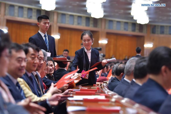 A staff member distributes ballots at the fourth plenary meeting of the first session of the 13th National Committee of the Chinese People's Political Consultative Conference (CPPCC) at the Great Hall of the People in Beijing, capital of China, March 14, 2018 (Xinhua/Li Tao)