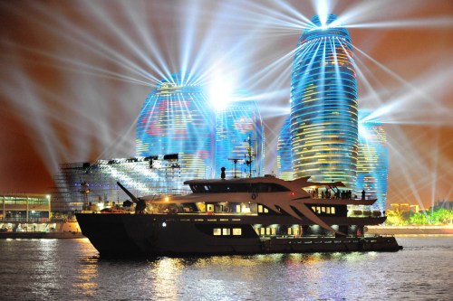 A yacht moves past the cruise ship hub in Sanya, Hainan province, during a nightly circuit in February. (Photo by Sha Xiaofeng/for China Daily)