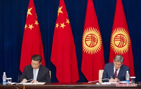 Chinese President Xi Jinping (L) and his Kyrgyz counterpart Almazbek Atambaev sign a joint declaration on establishing a strategic partnership between the two countries, in Bishkek, Kyrgyzstan, Sept. 11, 2013. (Xinhua/Huang Jingwen)