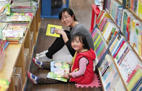 A mother and daughter are seen reading in Sanlian Taofen Bookstore, April 22, 2014. Sanlian Taofen Bookstore (STB) in Dongcheng District expanded its operating hours round the clock on April 8. [Photo /Beijing News] 