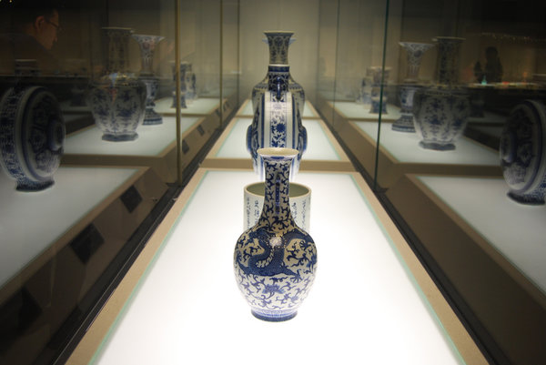 A range of white-and-blue glazed porcelain ware enclosed by a large glass dome attracts visitors' attention due to the clear and bright colors reflected by from the glass dome. (Photo: Women of China/Jin Jin)