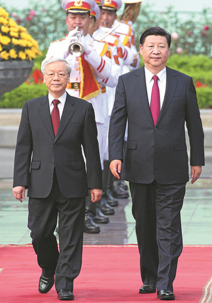 Xi Jinping, general secretary of the Communist Party of China Central Committee, walks with Nguyen Phu Trong, Xi's counterpart in Vietnam's Communist Party, during a welcoming ceremony in Hanoi on Sunday. (FENG YONGBIN / CHINA DAILY)