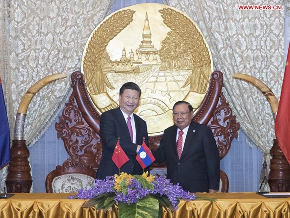 Chinese President Xi Jinping (L), also general secretary of the Communist Party of China Central Committee, shakes hands with Bounnhang Vorachit, general secretary of the Lao People's Revolutionary Party (LPRP) Central Committee and president of Laos, while jointly witnessing the signing of bilateral cooperation documents after their talks in Vientiane, Laos, Nov. 13, 2017. (Xinhua/Wang Ye)