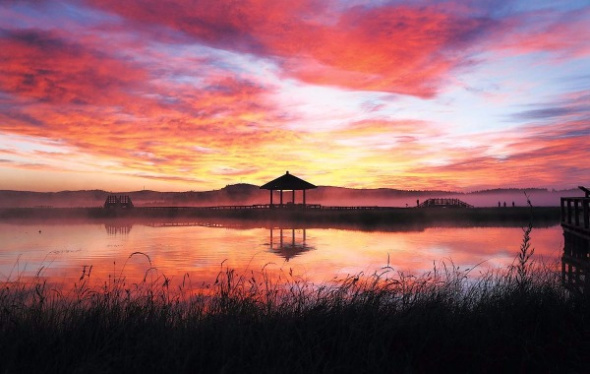 The sun rises over Qixing Lake in the Saihanba National Forest Park on the border of Hebei province and the Inner Mongolia autonomous region. (Zou Hong/China Daily)