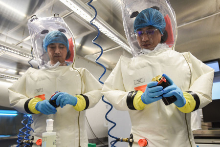 Virologists read data on a container for viral samples at China's first level-four biosafety lab at the Institute of Virology in Wuhan, Hubei province, on Wednesday. (Photo/China Daily)