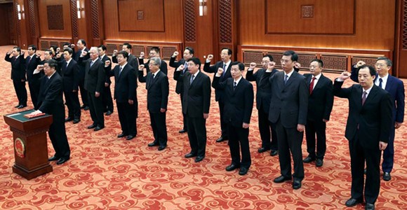 He Lifeng, head of the National Development and Reform Commission, leads newly appointed ministers, commission heads, the governor of the People's Bank of China and the auditor-general of the National Audit Office in an oath to uphold the Constitution, on the sidelines of the 13th National People's Congress in Beijing on Monday. (Photo by Pang Xinglei/Xinhua)