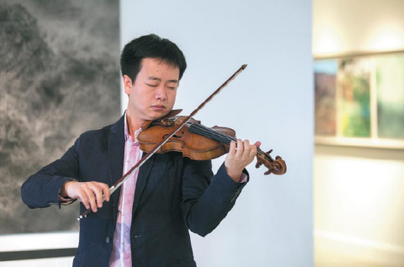Beijing-based legal consultant and amateur violinist Zhang Maolun plays the Italian Carrassi violin owned by renowned Chinese violinist Liu Xiao, which is the target of a violin crowdfunding program launched by Zhang and his friend. Photo provided to China Daily