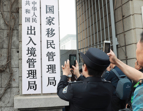 People photograph the State Immigration Administration's name plate after it was installed on Monday. (Photo provided to China Daily)