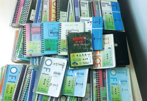 A collection of notebooks is shown in which passengers from around the world left their messages for taxi driver Jiang Wensheng. (Photo provided to China Daily)