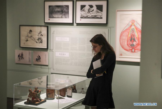 A visitor looks at exhibits during the press preview of Chinese Medicine in America: Converging Ideas, People and Practices and On the Shelves of Kam Wah Chung & Co. in the Museum of Chinese in America in New York, the United States, April 25, 2018. (Xinhua/Wang Ying)