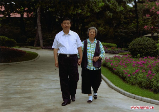 An undated photo of President Xi Jinping walking with his mother. The photo is on Xi's bookshelves in his office. [Photo/Xinhua]