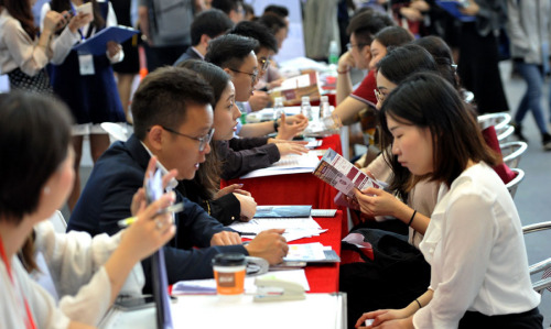 Returnees chat with prospective employers at a job fair in Shenzhen, Guangdong Province. (Photo by Xuan Hui/For China Daily)