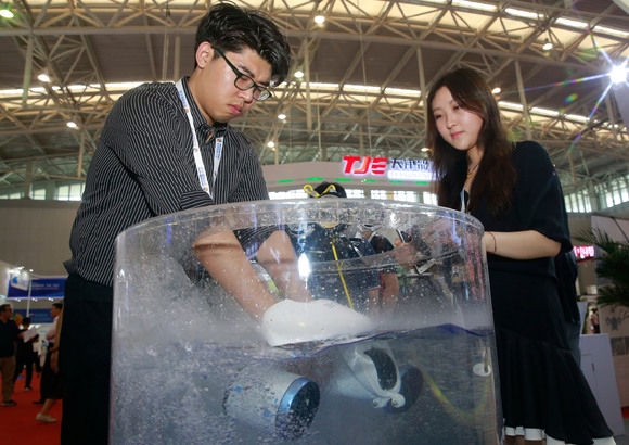Technicians demonstrate an intelligent assistor at the ongoing Second World Intelligence Congress in Tianjin. Photo by Jia Chenglong/For China Daily