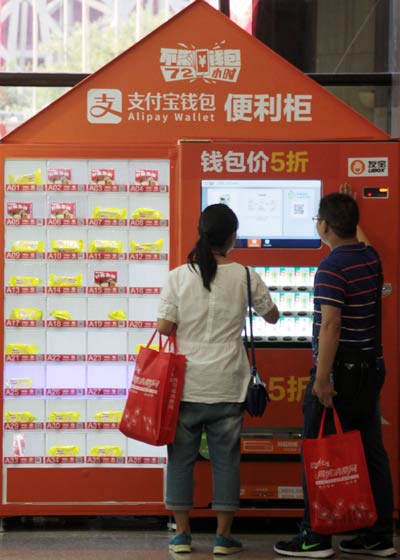 Visitors to an Internet conference, held in Beijng in August, use Alipay Wallet to pay for their shopping. Alipay rolled out the latest version of its mobile application on Tuesday. WU CHANGQING/CHINA DAILY